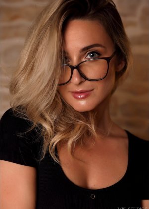 Белокурая модель снимает очки, прежде чем показать свое великолепное тело